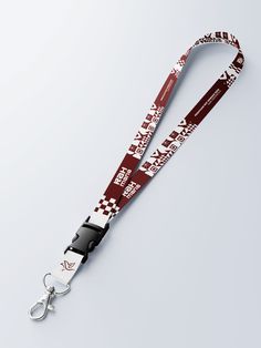 the lanyard strap is red and white with black letters on it, along with a pair of scissors