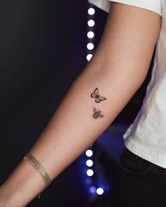 a woman's arm with a butterfly tattoo on the left side of her arm