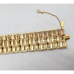 Goldtone articulated bracelet with fold over clasp and security chain. Marked "Monet." Measures:  7 3/8 inches long by 1 1/4 inches wide. Condition: Very good, minor wear to the bar the fold over clasp attaches to. From Monet's 1972 Fanchette line.  A necklace matching this bracelet is shown on pg. 222 of Alice Vega's book "Monet; the Master Jewelers." Metal Chain Bracelet With Clasp For Formal Occasions, Formal Metal Chain Bracelet With Clasp, Vintage Formal Chain Bracelet With Box Clasp, Vintage Link Bracelet With Clasp, Vintage Gold Link Bracelet, Vintage Link Bracelet, Necklace Matching, Wide Bracelet, The Fold