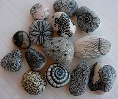 some rocks with designs on them sitting on a tile floor