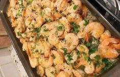 a pan filled with cooked shrimp on top of a stove