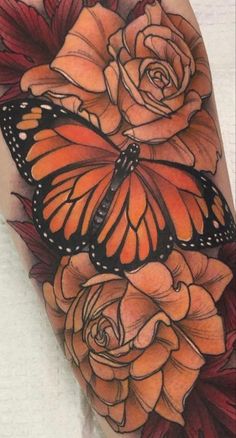 an orange butterfly sitting on top of some flowers next to a pink rose and red leaves