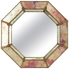 an octagonal mirror with pink and gold accents