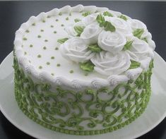 a green and white decorated cake on a plate