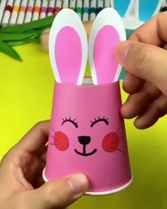 someone is holding up a pink cup with bunny ears on it