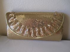 This is a wonderful 1970s gold Whiting & Davis evening clutch. The only evening bag you'll ever need!  It goes with everything. This one has a classy little ruffle along the edge, A great piece! Measures 8.5 inches by 5 inches. Large enough for you cell phone. There is one zippered pocket inside. In original box and with original tag. Wear it as a clutch or attach the 42 inch gold leather strap to wear as a shoulder bag. In minty vintage condition! Chic Gold Clutch For Dinner, Elegant Gold Evening Bag For Dinner, Gold Vintage Clutch For Events, Gold Vintage Clutch For Party, Vintage Gold Party Clutch, Vero Beach Fl, Foldover Clutch, Vero Beach, Evening Clutch