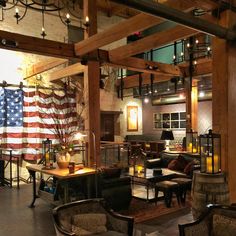 an american flag hanging in the middle of a room with tables and chairs around it