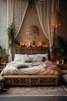 a bed with lots of pillows and blankets on top of it next to some plants