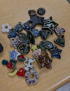 a table topped with lots of different types of glass buttons on top of a wooden table