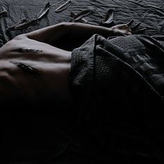 a shirtless man laying on top of a bed