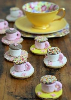 small cupcakes with pink frosting and sprinkles sitting on plates