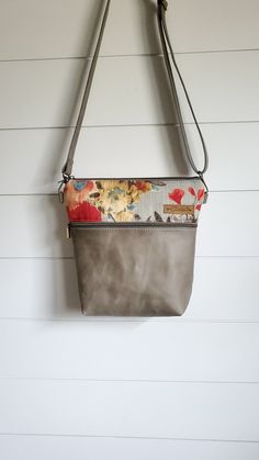 "This is a great everyday bag, with it's neutral color scheme! It is made from 100% cotton designer fabric, and beautiful gray genuine leather. It is lined with a sturdy cotton fabric in a neutral color. It is the perfect size for everyday use! Cute AND practical! Measures 10 in (w) at the bottom and 11 in (w) at the top, and approximately 12.5 in (h). The strap is 54\" inches long, and adjustable. 2 interior slip pockets Front zipper pocket  Zipper closure  Because I use a premium top grain lea Gray Pouch Shoulder Bag For Everyday, Everyday Gray Pouch Shoulder Bag, Taupe Crossbody Bag For Everyday Use, Gray Crossbody Bag With Cell Phone Pocket, Gray Leather Handle Satchel Shoulder Bag, Everyday Gray Shoulder Bag With Zipper Pocket, Gray Leather Handled Satchel Shoulder Bag, Everyday Taupe Crossbody Bag, Gray Leather Handles Crossbody Shoulder Bag