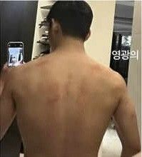 a man taking a selfie in front of a mirror with his back turned to the camera