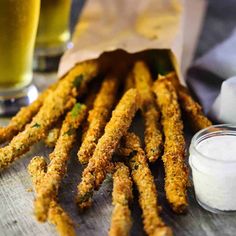 fried asparagus on a wooden table with beer in the background