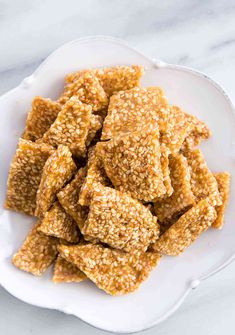 a white plate filled with sesame crackers on top of a table