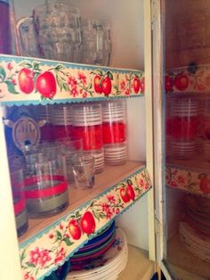 an open cupboard filled with dishes and plates