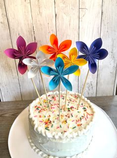 a white cake topped with frosting and colorful paper flowers