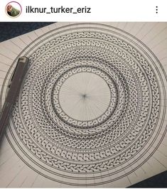 a pen is sitting on top of a paper with an intricate design in the middle