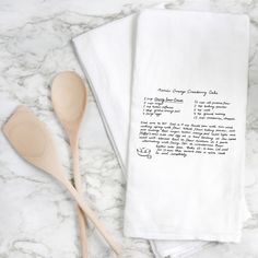 two wooden spoons sitting on top of a white towel