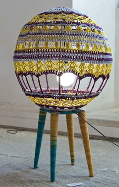 a yellow and purple lamp sitting on top of a wooden table