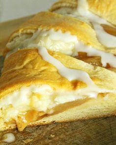 two pieces of bread with white icing sitting on a cutting board