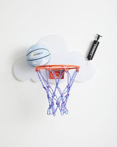 a basketball is on the rim of a basket in front of a cloud shaped wall