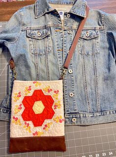 a denim jacket and purse sitting on top of a cutting board