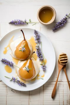 two pears on a plate with honey and lavender