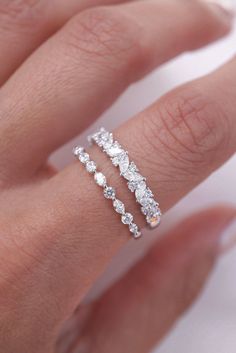 a woman's hand with two rings on it and one is wearing a diamond ring