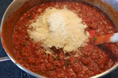 a pot filled with sauce and cheese on top of a stove