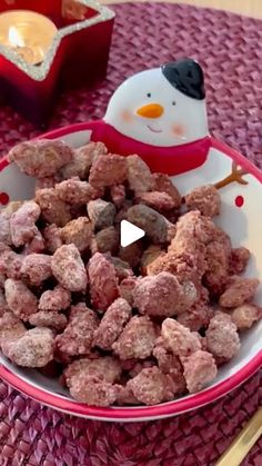 a bowl full of muddy dog treats with a snowman in the background on a table