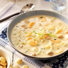 a bowl of soup on a table with silverware and spoons next to it