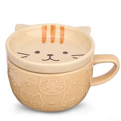 a ceramic cup with a cat design on the lid and handle, sitting in front of a white background