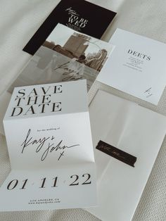 wedding save the date cards and envelopes on a bed