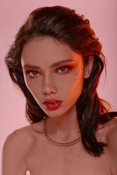 a woman with freckles on her face and red lipstick is posing for the camera