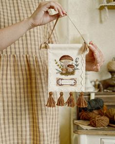 a woman is holding a small embroidered banner