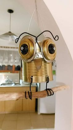 a tin can birdhouse made to look like a robot with two eyes on it