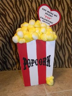 a red and white striped popcorn box filled with yellow candies next to a zebra print wall