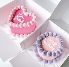 two pink and purple cakes in boxes with the words happy birthday written on them,