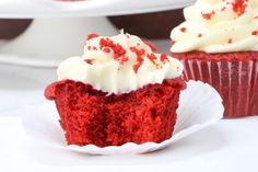 two red velvet cupcakes with white frosting