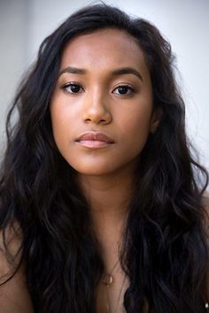 a close up of a woman with long hair and no shirt looking at the camera