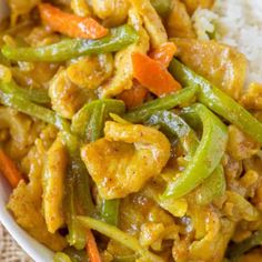 a white bowl filled with chicken and veggies next to rice on a table