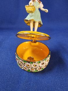 an angel figurine sitting on top of a trinket box with lid