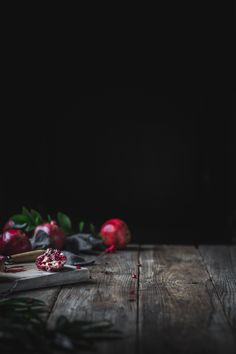 pomegranates on a wooden table with leaves