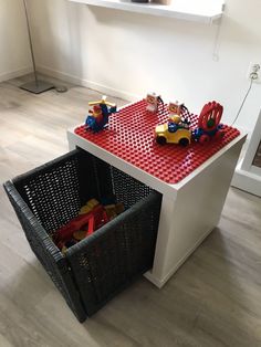 a lego table with toy cars and toys in the bins on top of it