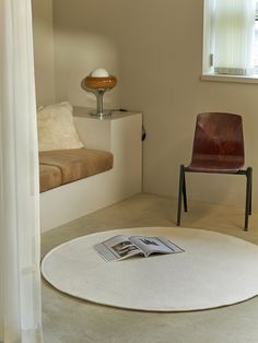 a chair sitting on top of a white rug next to a window