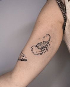 a woman's arm with a scorpion tattoo on it and a butterfly in the background