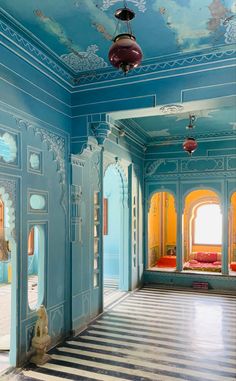 an ornately painted hallway with blue walls and white flooring is pictured in this image