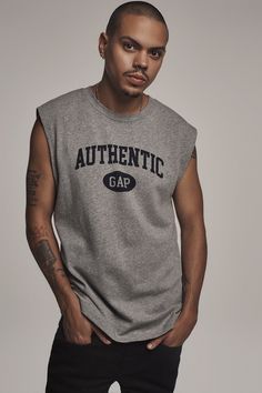 a young man wearing a grey shirt and black pants with the word authentic gap on it