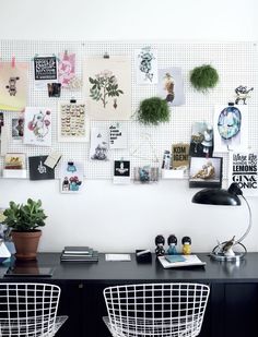 two black chairs sitting next to a desk with pictures on the wall